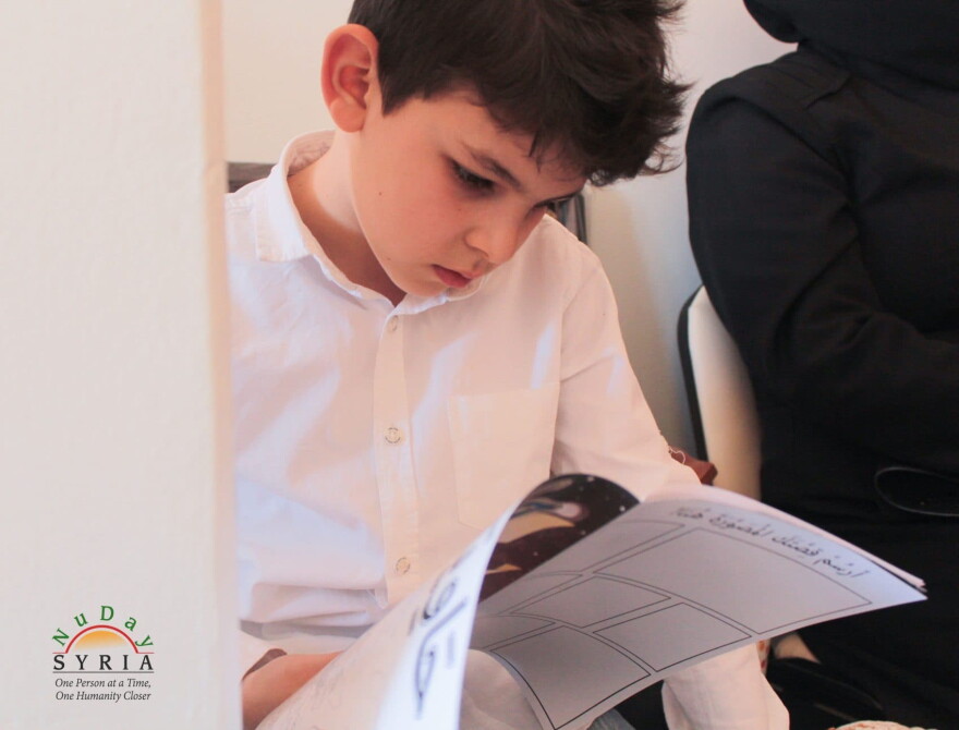 A Syrian refugee child reads the free comic book at a refugee camp in Turkey. (Courtesy NuDay Syria)