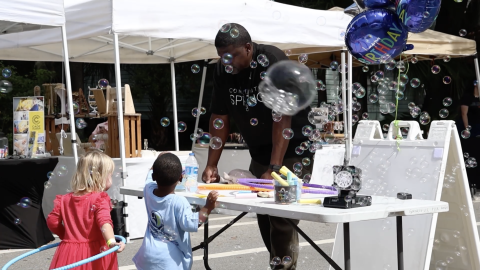 Children play with bubbles at Community Spring's block party.