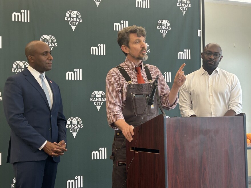 Jansen Adam is joined by Mayor Quinton Lucas and Lou Pieh at the podium during press conference.