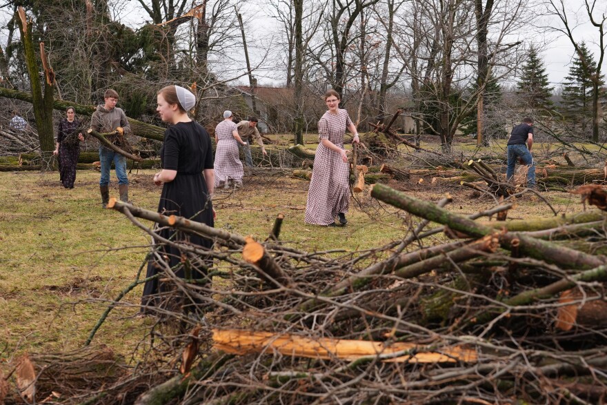 Volunteers work to clear branches after a tornado hit the area a day earlier in Union City, Mich., Saturday, March 7, 2026.