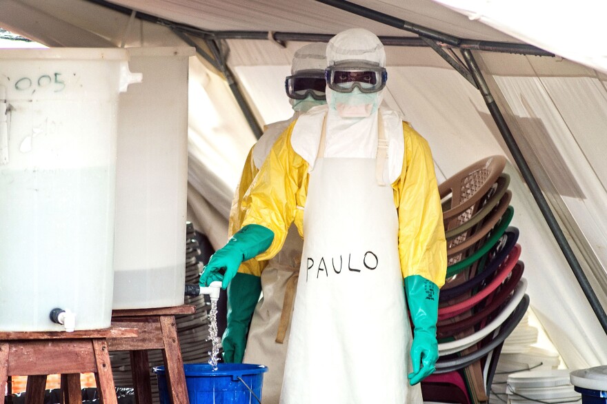 Protective gear runs from goggles and head covering to gloves and boots. This health worker was photographed leaving the isolation area at the treatment center in Kailahun, Sierra Leone.