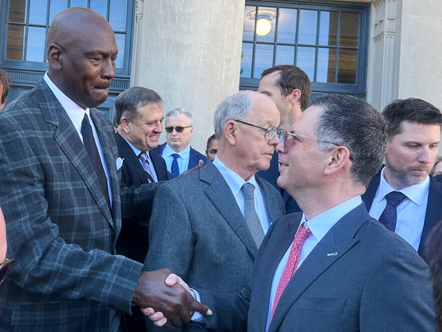Michael Jordan, left, shakes hands with NASCAR attorney Lawrence Buterman as NASCAR chairman Jim France, center, looks away, Thursday, Dec. 11, 2025, outside the federal courthouse in Charlotte, N.C.