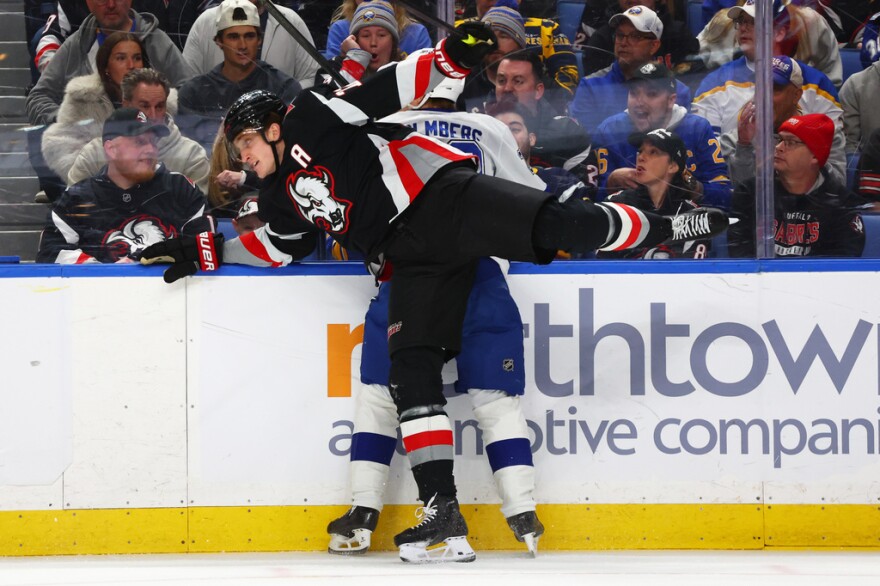 Buffalo center Tage Thompson checks Tampa Bay right wing Pontus Holmberg during the first period of the game in Buffalo on Monday, April 6, 2026. Holmberg left the game with an injury after falling into an open penalty box door later in the game.