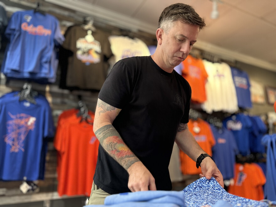 Alma Mater Custom Apparel owner Brian Meade folds Gators polos ahead of Labor Day weekend. He’s increasing the store’s stock and extending the hours of operation to prepare for more business. (Jeffrey Serber/WUFT News)