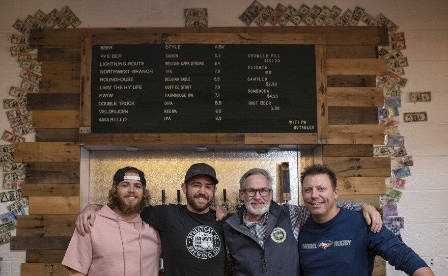 Bartender Zane Pederson (left) and co-founders Jon Cetrano, Mark Burke and Sam Costner stand behind the brewery's bar.