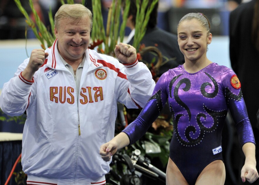 Aliya Mustafina celebrates with her coach, Alexander Alexandrov, after winning the gold medal in the women's individual all-around at the 2010 World Championships in the Netherlands. She suffered injuries that prevented her from competing in 2011.