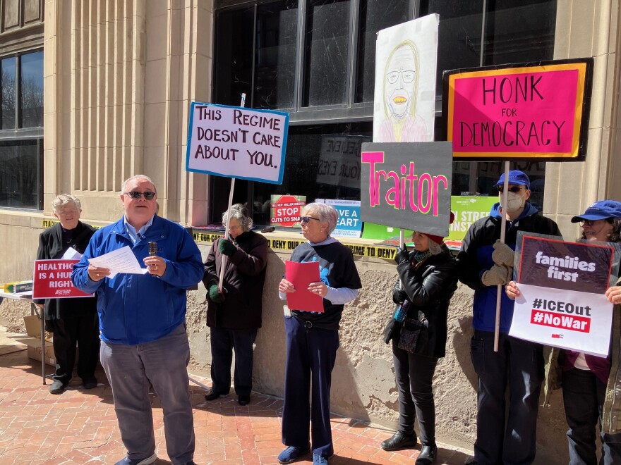 Jay Williams (in blue jacket, left) of Bettendorf, discusses the impact of the ACA on his own family and society.