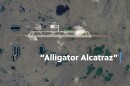 Aerial shot of brown land with text "Alligator Alcatraz" superimposed
