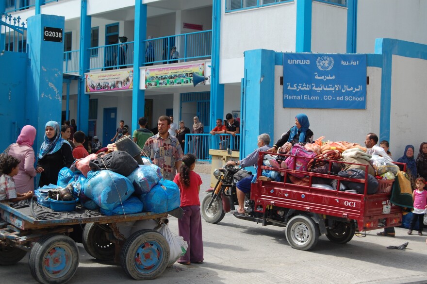 Palestinian families arrive at al-Remal Elementary School, which is run by the U.N. Relief and Works Agency, or UNRWA. The director of UNRWA operations in Gaza says the U.N. expects 50,000 evacuees to seek shelter at schools like this one.