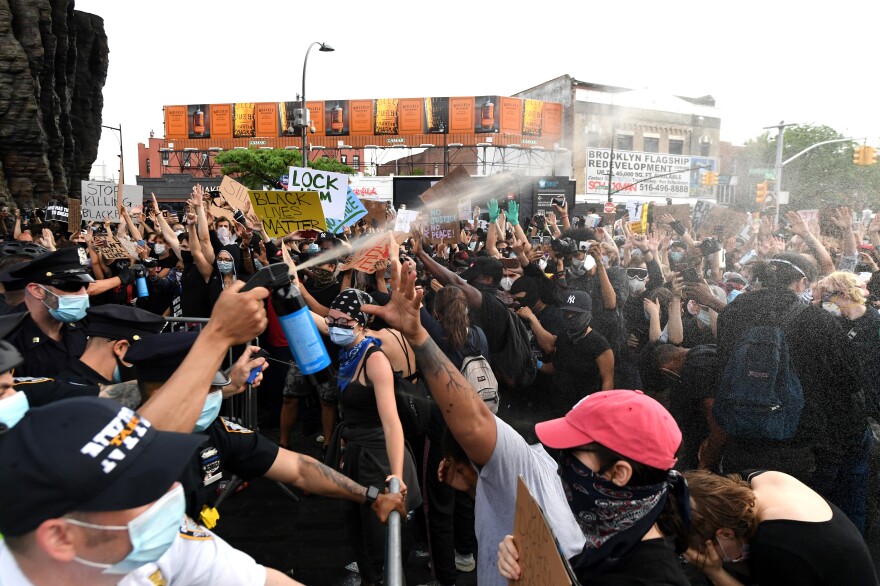 Police officers spray protesters outside Brooklyn's Barclays Center on May 29, 2020.