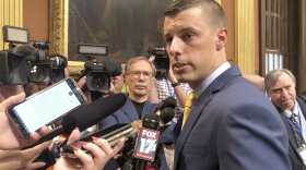 Three-quarter view of Chatfield facing a press scrum in 2019