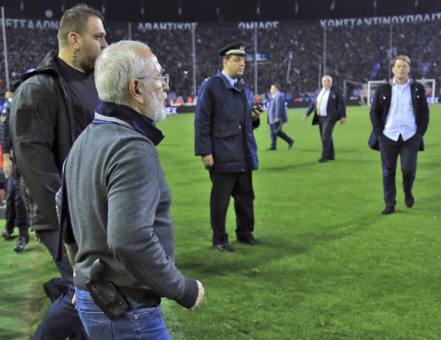 PAOK owner Ivan Savvidis invades the pitch during the Greek League soccer match between PAOK and AEK Athens in the northern Greek city of Thessaloniki on Sunday.
