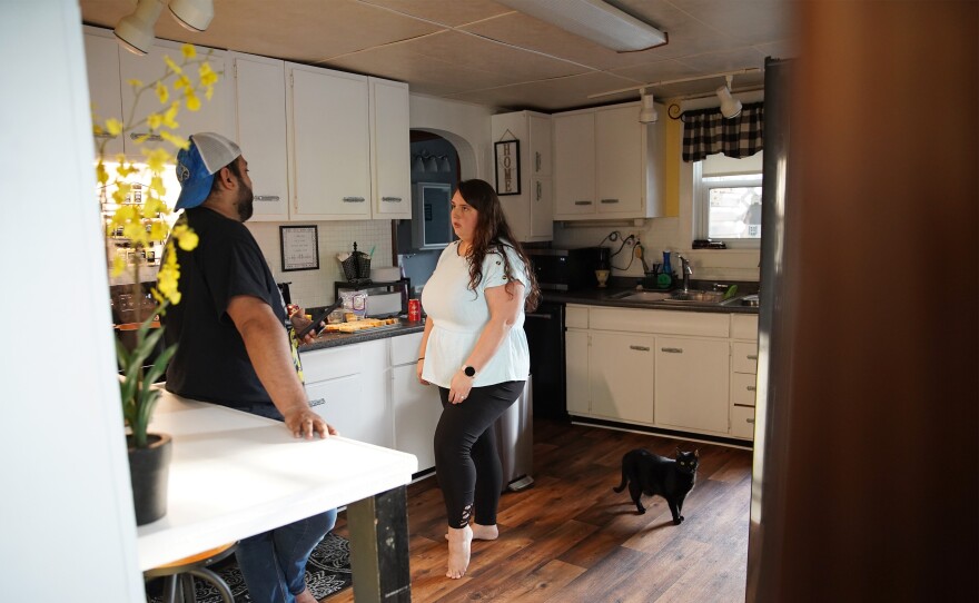 Tyler Tanner and Kelly Cunningham discuss bills while making dinner in their Mount Vernon home.