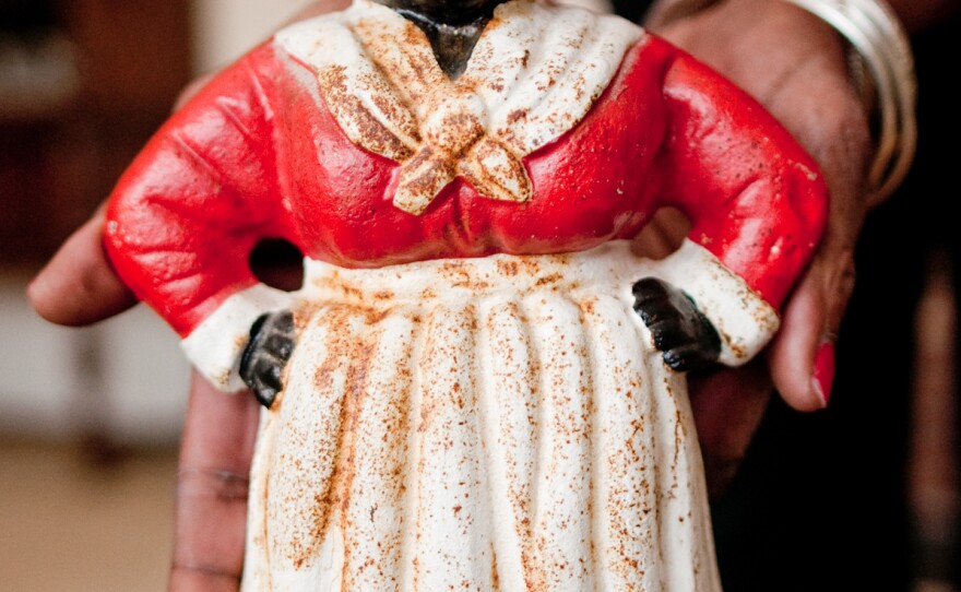 Dora Robinson holds the cast-iron figure of Aunt Jemima, originally used as a doorstop, which she found at a yard sale in upstate New York. 