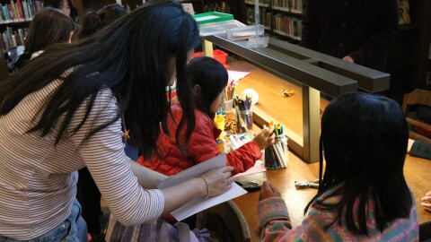 Kate Quach helps a group of elementary school students assemble their journals at a Golden Keepers workshop in West Portal Library.