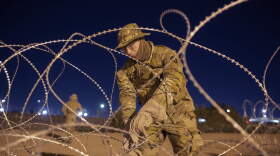 A Texas National Guard soldier ties rows of barbed-wire to be installed near a gate at the border fence in El Paso, Texas. (Andres Leighton/AP)