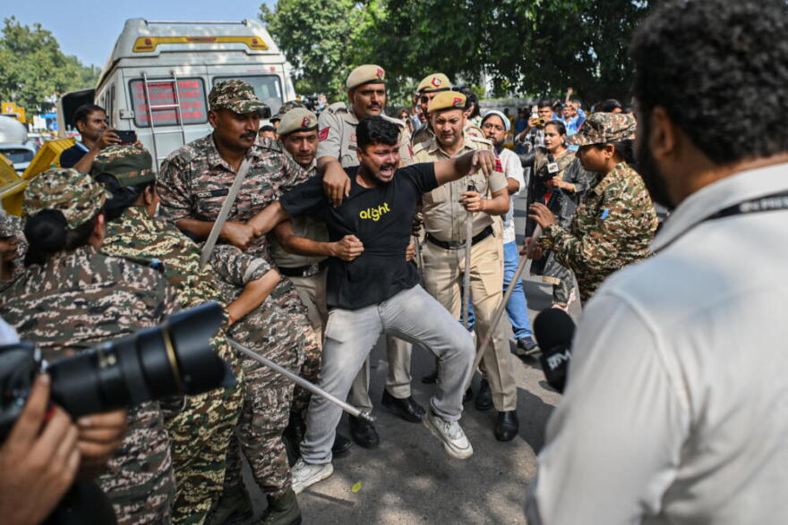 Police officers detain a protester during a demonstration on Oct. 10, 2026 in New Delhi, India. The Cockroach Janta Party (CJP) has called a mass protest to demand the resignation of India's Chief Election Commissioner, Gyanesh Kumar, over what they say are alleged irregularities in electoral processes and the revision of voter rolls. (Ritesh Shukla/Getty Images)