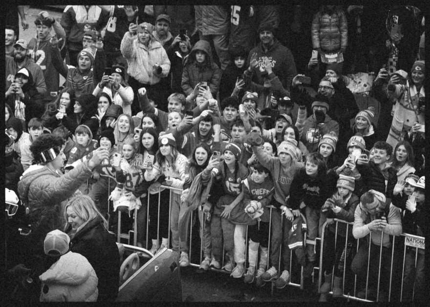  Chiefs quarterback Patrick Mahomes holds up a beer in front of a barricade of fans at the Super Bowl victory parade on Feb. 15, 2023.