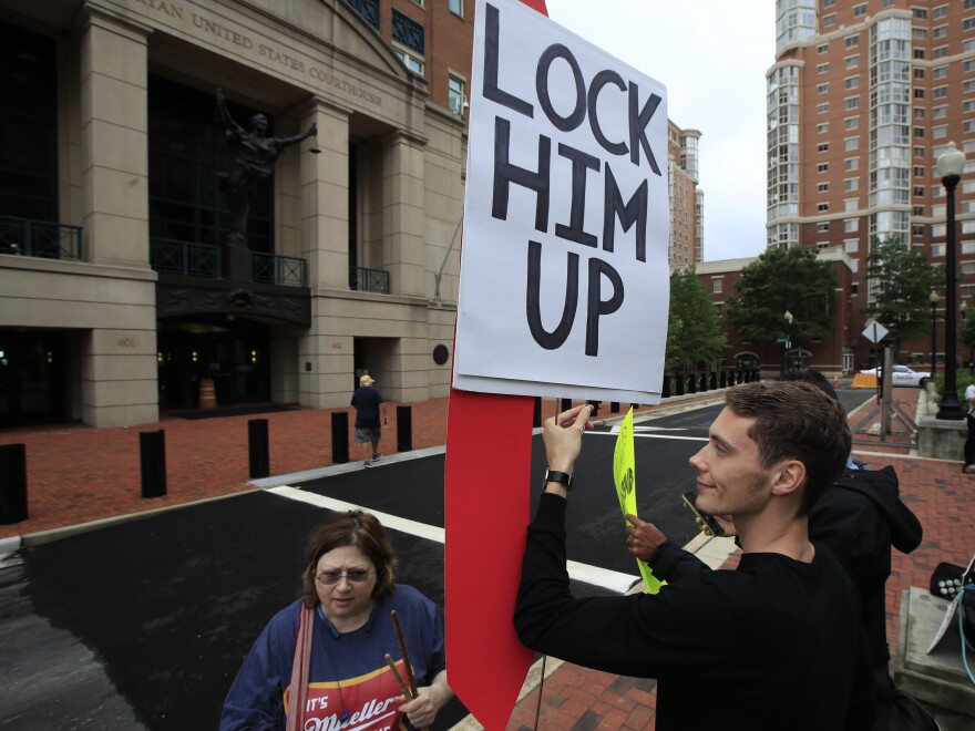 Gayelynn Taxey and Danny Hastings protest in front of the federal courthouse in Alexandria, Va., Tuesday.