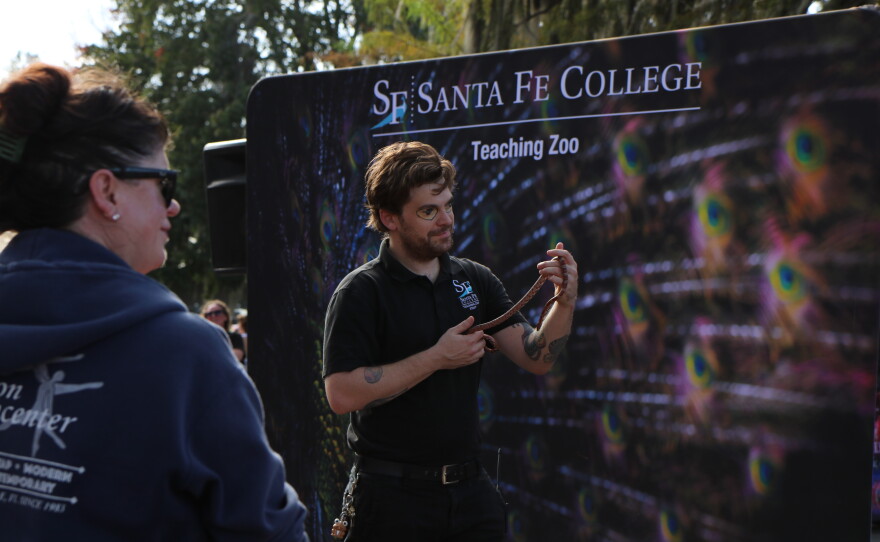 A Santa Fe College Teaching Zoo staff member shows off a snake to a crowd during Boo at the Zoo’s comedy play on Wednesday, Oct. 28, 2026. The play follows the story of a haunted house master trying to find scary animals while a zookeeper gives fun facts to reassure audience members that not all animals are as scary as they seem. (David Caine/WUFT News)