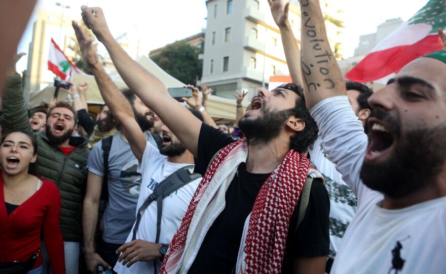 Lebanese anti-government protesters celebrate Hariri's resignation in Beirut on Tuesday.