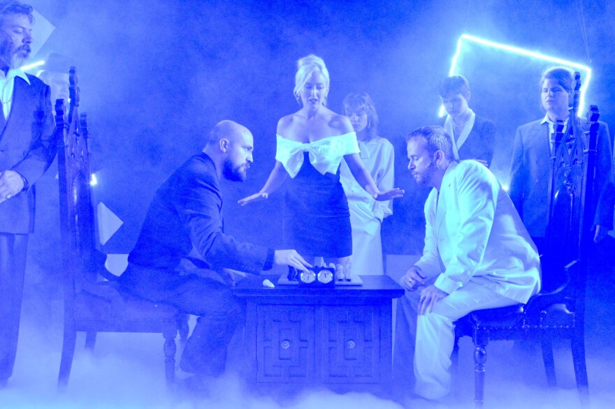 Dan Maxon (Anatoly) and Michael Finchum (Freddie) square off to play chess as Julie Peterson (Florence) looks on.