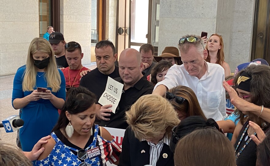 Supporters of the bill to ban mandatory vaccines in Ohio pray along with Rep. Jennifer Gross (West Chester).