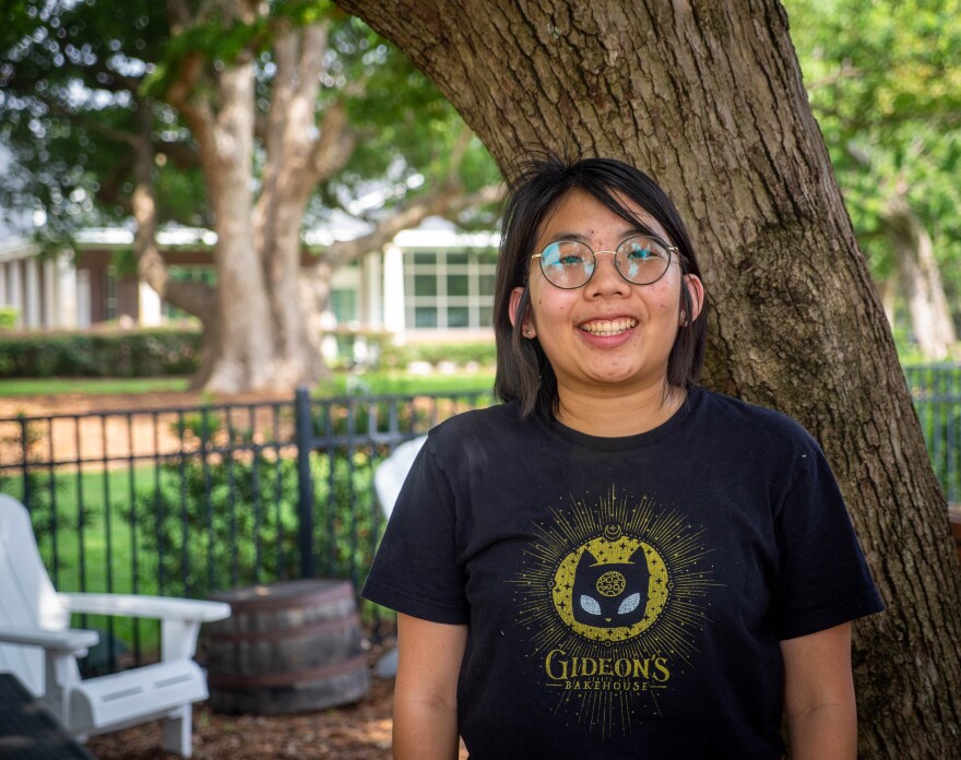 Chloe Becker poses in a park near her apartment in Lake Mary on July 28, 2026. Becker, who graduated from the University of Central Florida this spring with a degree in digital media, says she's seeing evidence that overreliance on generative AI has hurt critical thinking and reading comprehension skills for children and young adults.