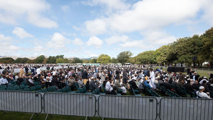 People listen to the call for prayer in Hagley Park in Christchurch, New Zealand, on Friday in memory of the victim of shooting attacks at two mosques one week earlier.