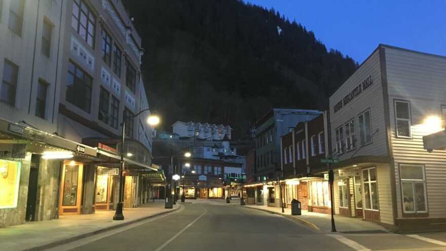 Street lights are turned on on a quiet downtown street.