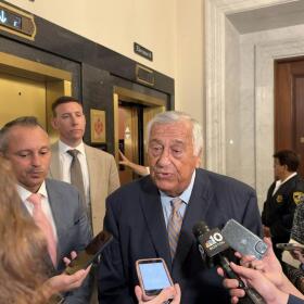 Mass. House Speaker Ron Mariano speaks to reporters at a scrum at the State House on July 30, 2026. House Ways and Means Chair Aaron Michlewitz is pictured on the left. Rep. Dan Cahill stands behind Mariano on the left, as does Rep. Alice Peisch on the right.