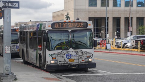 A bus at an intersection. The front screen reads "OUT OF SERVICE."