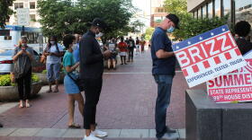 Indianapolis voters – many wearing masks – wait in line to vote at a polling place on Election Day.
