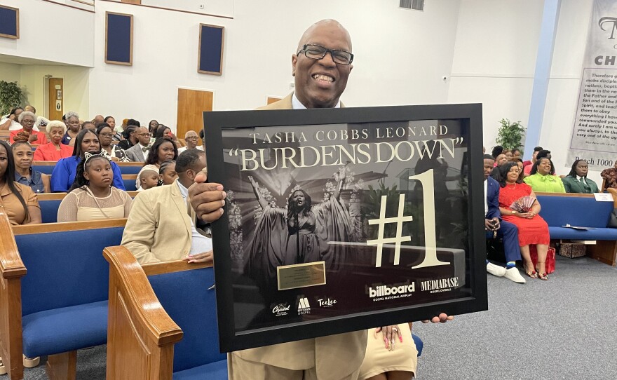 Rodney E. Evans holding a plaque from gospel music sensation Tasha Cobbs-Leonard commemorating his 40th Anniversary