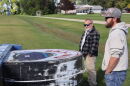 Steve Novak, left, and Chris Novak, right, look at the downed marquee of Sky-Vu in Warren, Minn., on Sunday. The wind's strength was so great that it bent over the metal poles that held up the sign. | MPR News