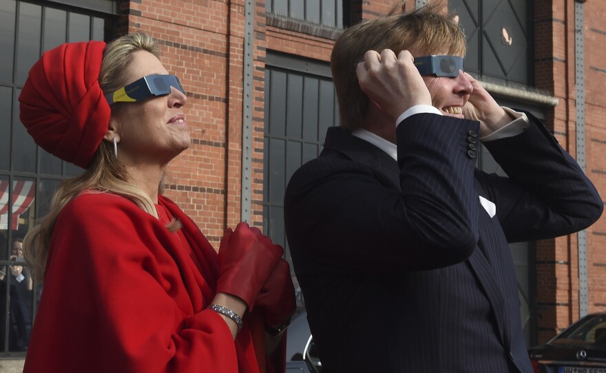 Dutch King Willem-Alexander and Queen Maxima wear protective glasses as they watch the partial solar eclipse in Hamburg, Germany.