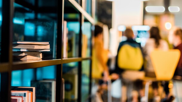 books on bookshelves and schoolchildren sitting behind in library