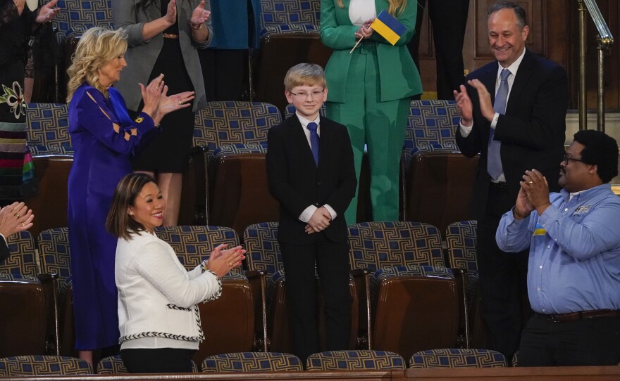 Joshua Davis of Midlothian, Va., center, stands as President Joe Biden acknowledges him during the first State of the Union address to a joint session of Congress, at the Capitol in Washington, Tuesday, March 1, 2022.