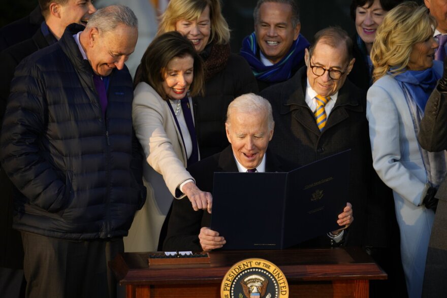 President Joe Biden reacts with House Speaker Nancy Pelosi of Calif., after he signs the Respect for Marriage Act, Tuesday, Dec. 13, 2022, on the South Lawn of the White House in Washington. At left is Senate Majority Leader Chuck Schumer of N.Y., and second from right is Rep. Jerrold Nadler, D-N.Y. (AP Photo/Andrew Harnik)