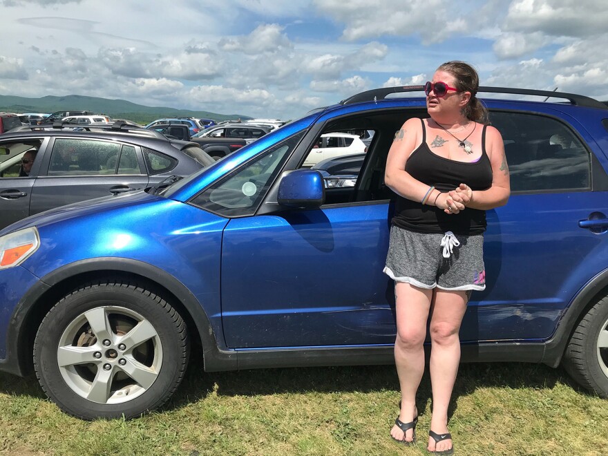 A woman standing outside her car.