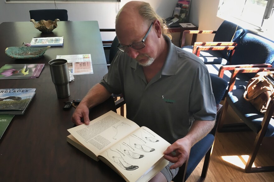 Jerry Lorenz, director of research for Audubon Florida, looks at the monograph on flamingos written by Robert Porter Allen, who established the science center in Tavernier.