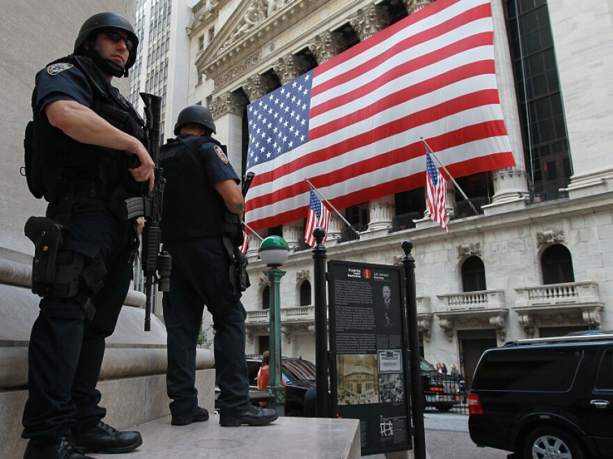 New York City policemen stand guard near the New York Stock Exchange on Friday. Security in New York and Washington has been stepped up based on what the government is calling a credible but unconfirmed threat of a possible car bomb attack.
