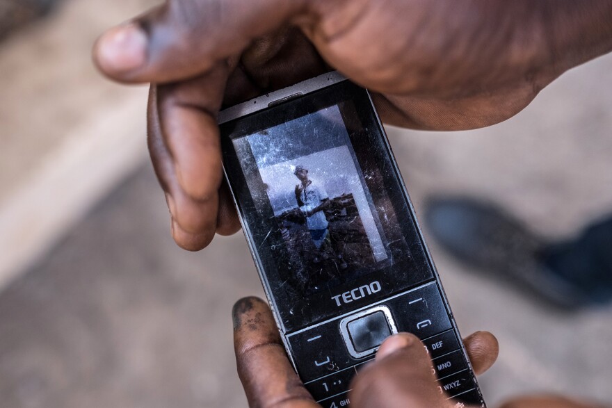 Samuel Senessie, 25, displays a picture of his brother, who died in last year's landslide, along with four other family members. Senessie never received the government support to which he should be entitled.