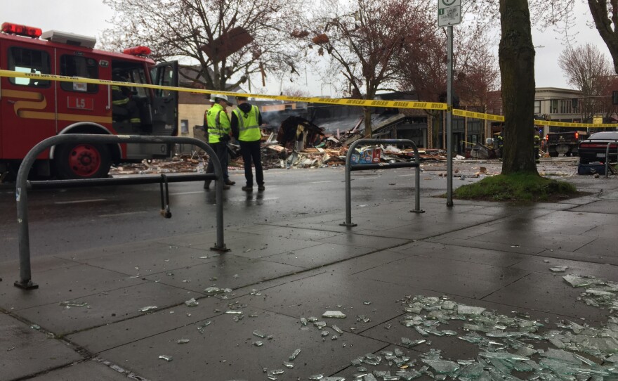 Glass covers a sidewalk at the scene of a gas leak explosion in Seattle's Greenwood neighborhood in the early hours of Wed., March 9, 2016.