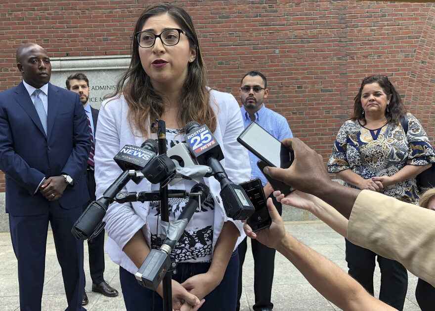Lilian Calderon answers questions during a lunch break outside Boston federal court on Monday. The American Civil Liberties Union argued a case on behalf of couples that federal immigration officials are violating the rights of immigrants seeking legal status by setting a deportation "trap" at their required marriage interviews. (Philip Marcelo/AP)