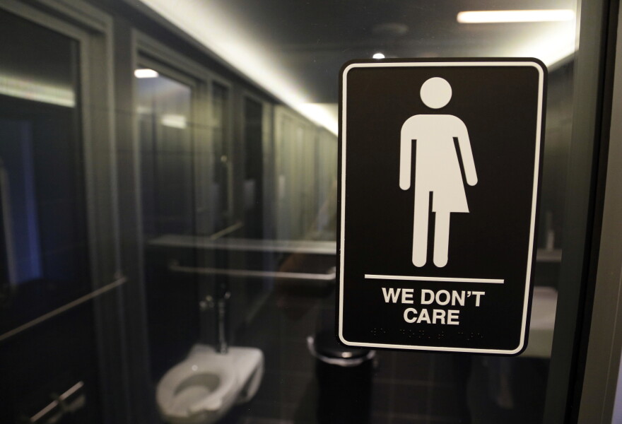 In this May 12, 2016, file photo, gender free sign hangs outside a restroom at 21c Museum Hotel in Durham, N.C.