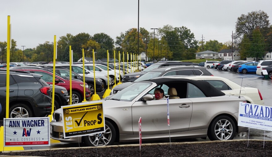 Rhonda Holstien waits in her car to vote curbside at the St. Louis County Board of Elections in St. Ann on Oct. 27. The yellow poles mark parking spots reserved for curbside voting.