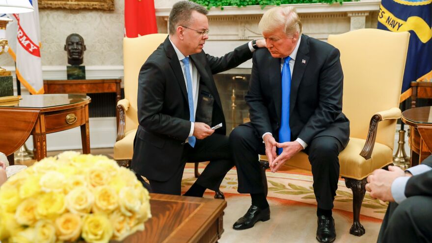 Pastor Andrew Brunson prays for President Trump at the White House on Saturday.