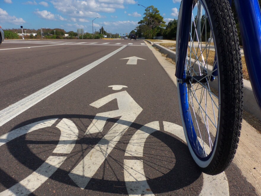 The front wheel of a bike on a marked bike path
