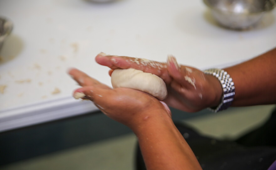 A student shapes their frybread dough, readying it for frying.